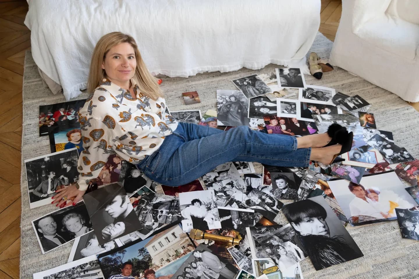 Daphné Rotcajg, wearing Régine’s blouse and shoes, sitting among photographs of her grandmother